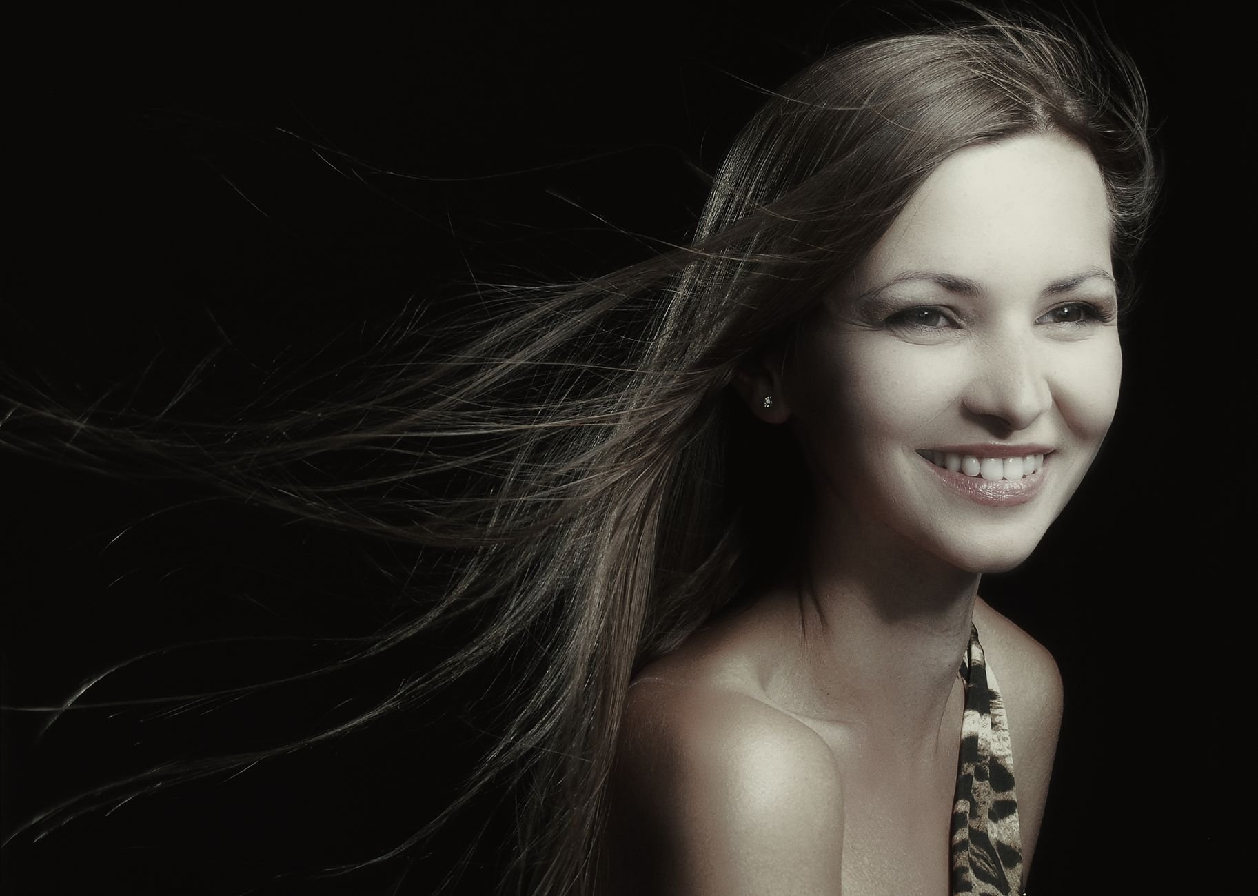 Woman with striking, flowing hair — confident studio portrait